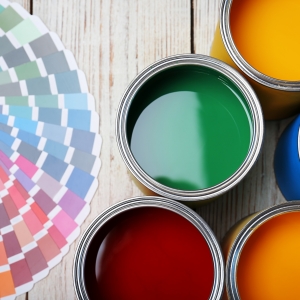 Cans with paint and color palette on wooden background, top view